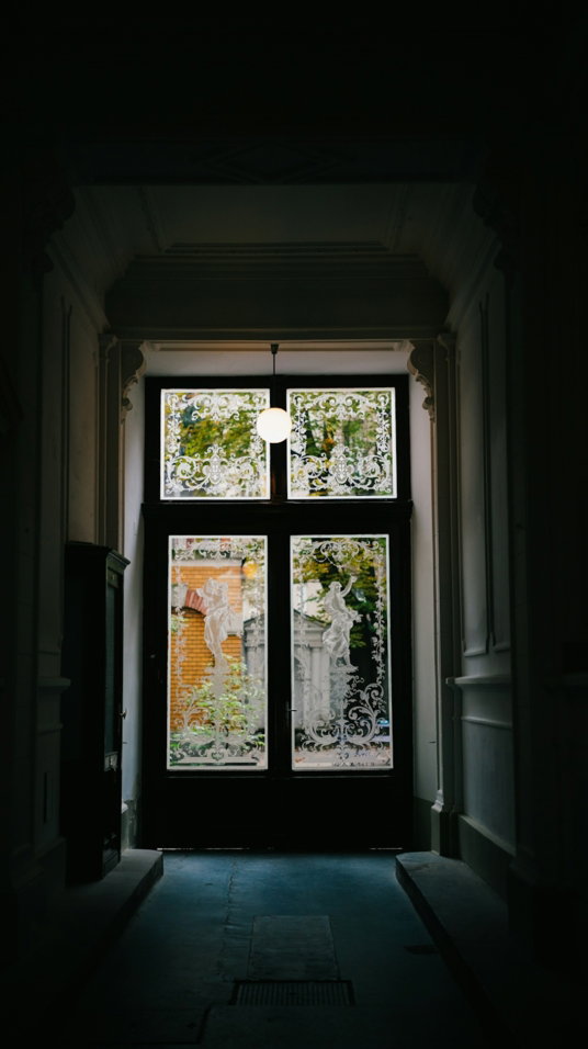 A dark hallway leading to a large window